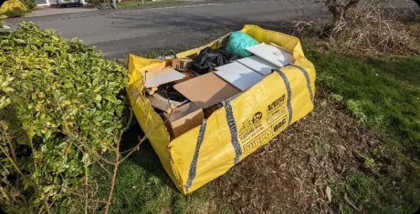 Hippo bag full of rubbish in a garden