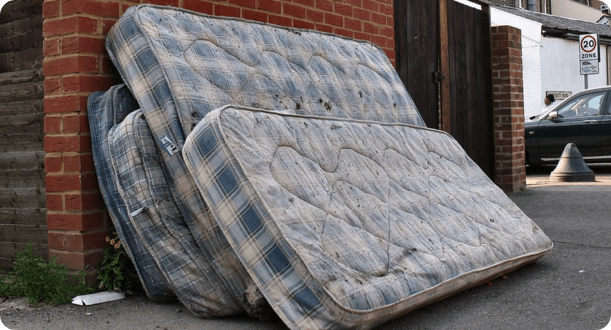 4 mattresses leant against a wall