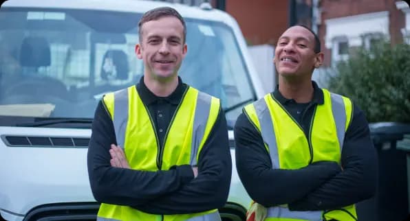 Two service partners smiling in front of a truck